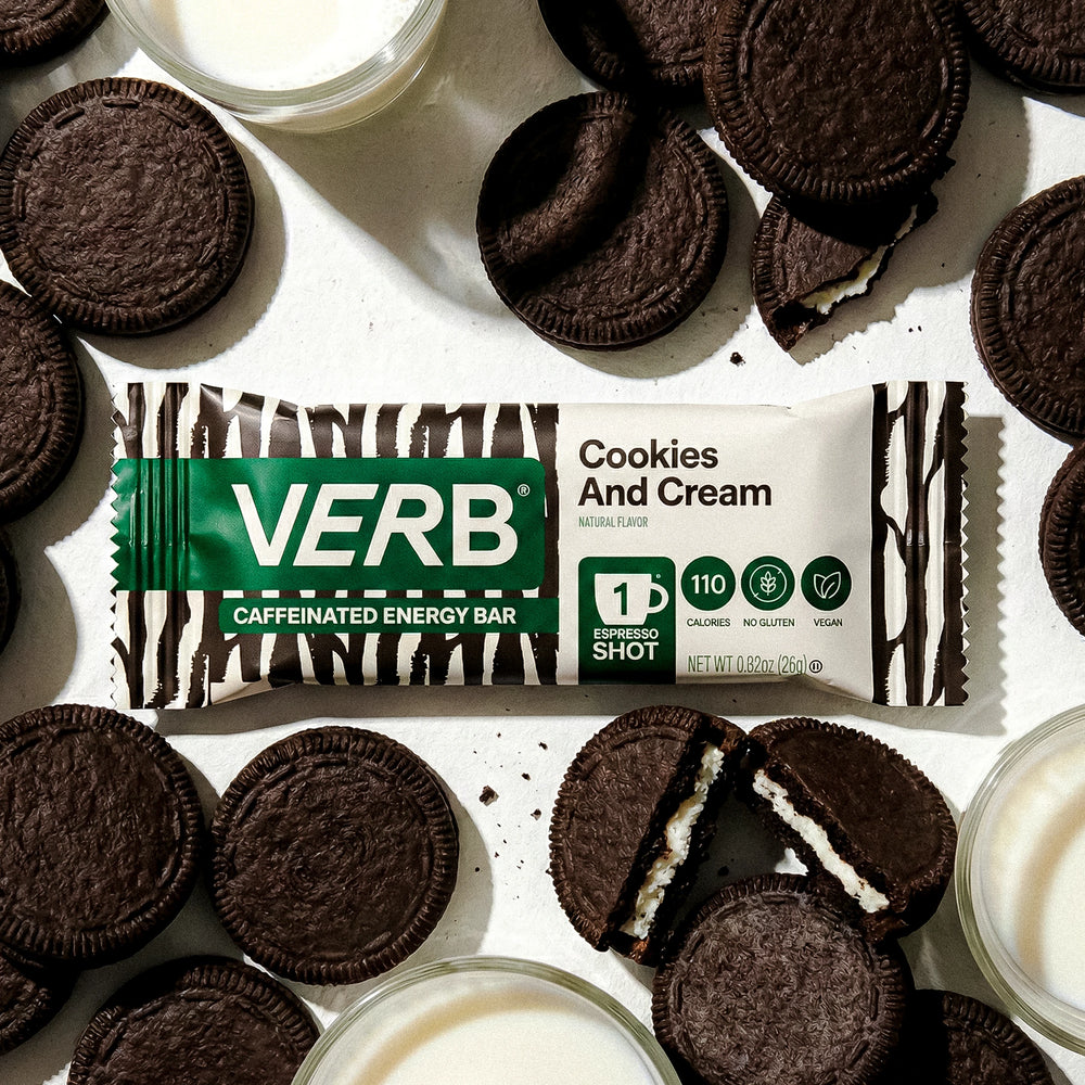 Verb energy bar with cookies and cream flavor surrounded by cookies and a glass of milk.