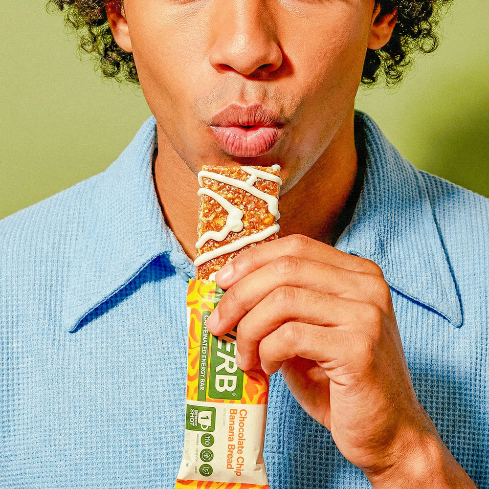 Person holding a protein bar with a green background